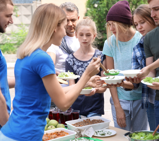 Volunteers serve food to young people