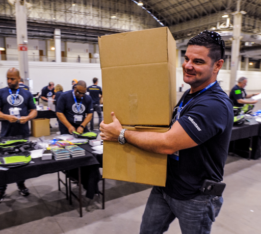 An Allstate employee volunteer carries a box full of supplies for the homeless.